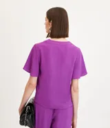 Blusa color violeta con cuello en V, mangas cortas con volados y textura airflow.