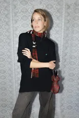 Buzo de punto color azul marino con diseño de conejos bordados a mano en la espalda en tonos rojizos y detalles de puntos verdes en el ruedo. Presenta cuello redondo y mangas largas.