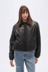 Campera estilo bomber de eco-cuero negra, con cuello camisero, cierre frontal y puños y cintura ajustados con elástico.