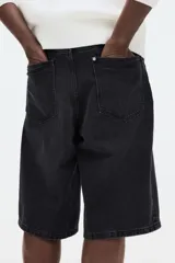 Bermuda de cinco bolsillos en denim de algodón rígido, con corte holgado tipo baggy, tiro caído y pierna amplia.