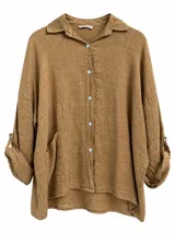 Camisa de lino color tostado, de corte oversize, con mangas largas arremangables mediante presilla, cuello camisero y bolsillos frontales.