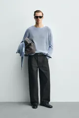 Pantalón de corte wide fit confeccionado en algodón con efecto lavado. Presenta pliegues frontales, bolsillos laterales y bolsillos traseros de vivo. Cierre frontal con cremallera y gancho metálico oculto.
