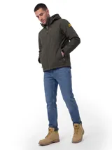 Chaqueta técnica de color verde oliva, diseñada con tecnología Storm Blocker+ para protección contra agua y viento. Cuenta con capucha extraíble y ajustable, cierre frontal impermeable, bolsillo en el pecho y bolsillos laterales con cierres impermeables en contraste amarillo. Incluye aislamiento térmico de poliéster reciclado y ajustes elásticos en capucha y dobladillo.