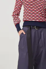 Pantalón negro de gabardina liviana de algodón, tiro alto con pinzas delanteras, bolsillos americanos y cierre metálico.