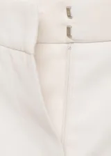Pantalón de vestir color crema, de corte recto, con cierre de botón y cremallera, tiro medio y bolsillos laterales. Ideal para fiestas y ceremonias.