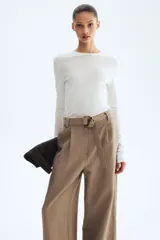 Pantalón de tiro alto con corte holgado y piernas amplias, color marrón, con pliegues delanteros y cinturón del mismo tejido con hebilla circular.