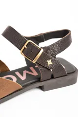 Sandalias cangrejeras de cuero tipo flats, con diseño bicolor en tonos marrón y tostado, tiras entrelazadas en el empeine y tira ajustable con hebilla en el talón.