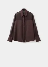 Camisa de tejido semitransparente color marrón oscuro, con cuello camisero, cierre frontal de botones ocultos y mangas largas con puños abotonados.