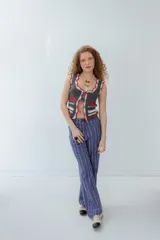 Pantalón de vestir azul con estampado de rayas verticales finas en blanco. Corte recto o ligeramente acampanado, con cierre frontal de botón visible.