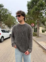 Sweater de punto con diseño de trenzas verticales, color gris oscuro con efecto lavado, de corte holgado y fit boxy, con cuello redondo y puños acanalados.