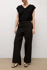 Pantalón sastrero de corte recto y tiro medio, en color beige claro, con presillas para cinto y bolsillos funcionales.