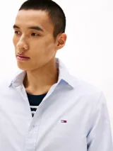 Camisa celeste de algodón Oxford, corte regular, cuello abotonado, puños redondeados con botón, logo de Tommy Jeans bordado en el pecho.