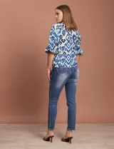 Blusa de gasa estampada en tonos azules y negros, marca Sioni. Tiene cuello a la base con escote en V, abertura central con botones y mangas tres cuartos fruncidas.