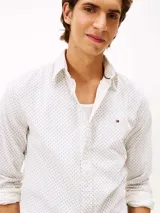 Camisa de manga larga confeccionada en algodón regenerativo con tejido de pana. Presenta un diseño estampado de pequeños motivos geométricos, cuello clásico con botones y cierre frontal abotonado. Incluye el logo de la marca bordado en el pecho.