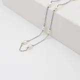Gargantilla de cadena fina de plata 925 con perlas de río naturales distribuidas a lo largo de la pieza.