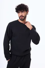 Buzo de felpa color negro, con cuello redondo, mangas largas y puños elásticos. Diseño básico y minimalista.