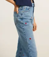 Pantalón mom jeans celeste con bordados de frutillas rojas.