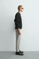 Pantalón chino de corte slim fit, confeccionado en tejido elástico. Presenta bolsillos frontales, bolsillos traseros de vivo con botón y cierre frontal con cremallera y botón.