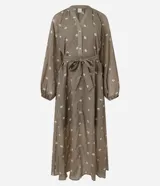 Vestido largo evasê color marrón con estampado de flores blancas, cuello en V, mangas largas abullonadas y cinturón de lazo.