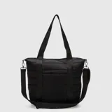 Bolso tipo tote color negro con diseño acolchado horizontal. Cuenta con doble asa de mano y una correa larga ajustable y extraíble, ambas con el logo de la marca estampado. Incluye cierre principal y compartimento interno protector para dispositivos electrónicos.