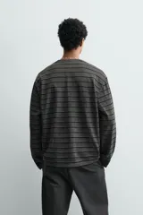 Camiseta relaxed fit de manga larga, color gris oscuro con rayas horizontales negras y efecto lavado.