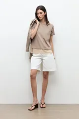 Remera oversized color topo con detalle de encaje en el ruedo, de manga corta y cuello redondo.