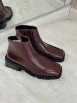 Botas cortas color bordó con punta cuadrada, suela negra y cierre lateral.