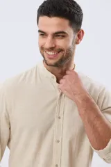 Camisa de lino y algodón color blanco, con cuello mao, manga larga y cierre frontal de botones. Presenta un pequeño logo bordado en el pecho.