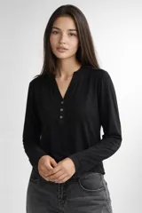 Remera de manga larga confeccionada en viscosa, con cuello en V y cierre frontal parcial con botones.