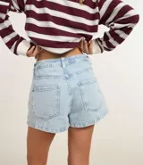 Short pollera de jean celeste con tiro alto, bolsillos delanteros y traseros, y trabillas en la cintura.