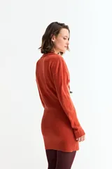 Vestido corto de tejido de punto color beige, manga larga y cuello polo con escote en V.