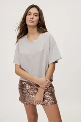 Remera gris de fit amplio, con mangas cortas y cuello redondo. Presenta efecto lavado y estampa frontal con aplicación de strass con la frase "fiesta mode on".