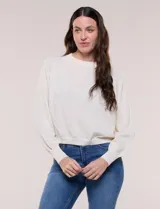 Buzo cropped de tejido texturizado color blanco, con cuello redondo, mangas largas raglán con puños acanalados y pretina elastizada en la cintura.