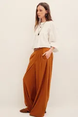 Pantalón ancho negro de tiro medio, con bolsillos laterales y pinzas frontales.