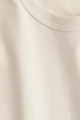 Remera color crema de algodón y viscosa, con cuello redondo y hombros caídos.