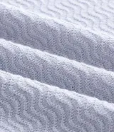 Polo de corte slim color gris claro, confeccionado en tejido de viscosa texturizado. Presenta cuello polo, cierre frontal con cremallera y mangas cortas.