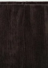 Pantalon de corte recto confeccionado en tejido de pana color marrón oscuro, con cintura elástica.