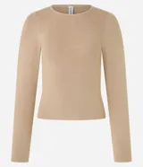 Blusa de manga larga confeccionada en tejido jacquard, con cuello redondo y diseño ajustado al cuerpo.