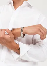 Pulsera de eslabones de acero quirúrgico plateado con ranuras diagonales.