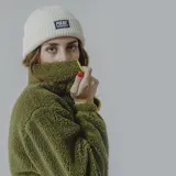 Buzo de sherpa color celeste con corte a la altura del pecho y bolsillo de nylon azul con logo estampado.