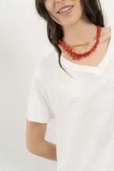 Remera blanca de algodón orgánico, con escote en V, mangas cortas y corte A-line. Cinta aplicada en la espalda con bordado de palmera.