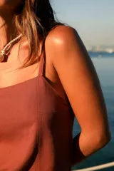 Vestido corto marrón de lino y rayón, con escote recto, tirantes finos y tajo lateral.