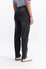 Jean mom de tiro medio con corte relajado y diseño de cinco bolsillos. Presenta un acabado lavado en tono gris oscuro.