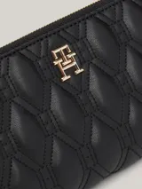 Billetera Tommy Hilfiger negra de piel sintética acolchada con cierre de cremallera y logo metálico dorado.