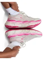 Championes Under Armour modelo W HB Runner 2, de color beige con detalles en fucsia, diseño con suela chunky y capellada de malla transpirable.