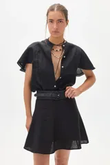 Camisa negra de lino con cuello mao, mangas cortas acampanadas y botonadura frontal con botones de nácar.