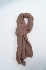 Pañuelo rectangular de textura arrugada con bordes desflecados.