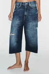 Bermuda de jean tiro medio, corte baggy y diseño holgado con detalle de rotos y cinco bolsillos.