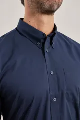 Camisa azul de algodón con elastano, cuello button-down y manga larga.