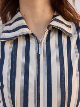 Enterito largo de denim color verde militar, sin mangas, con cuello camisero, cierre frontal completo y bolsillos laterales. Incluye cinturón ajustable del mismo material con hebilla metálica.